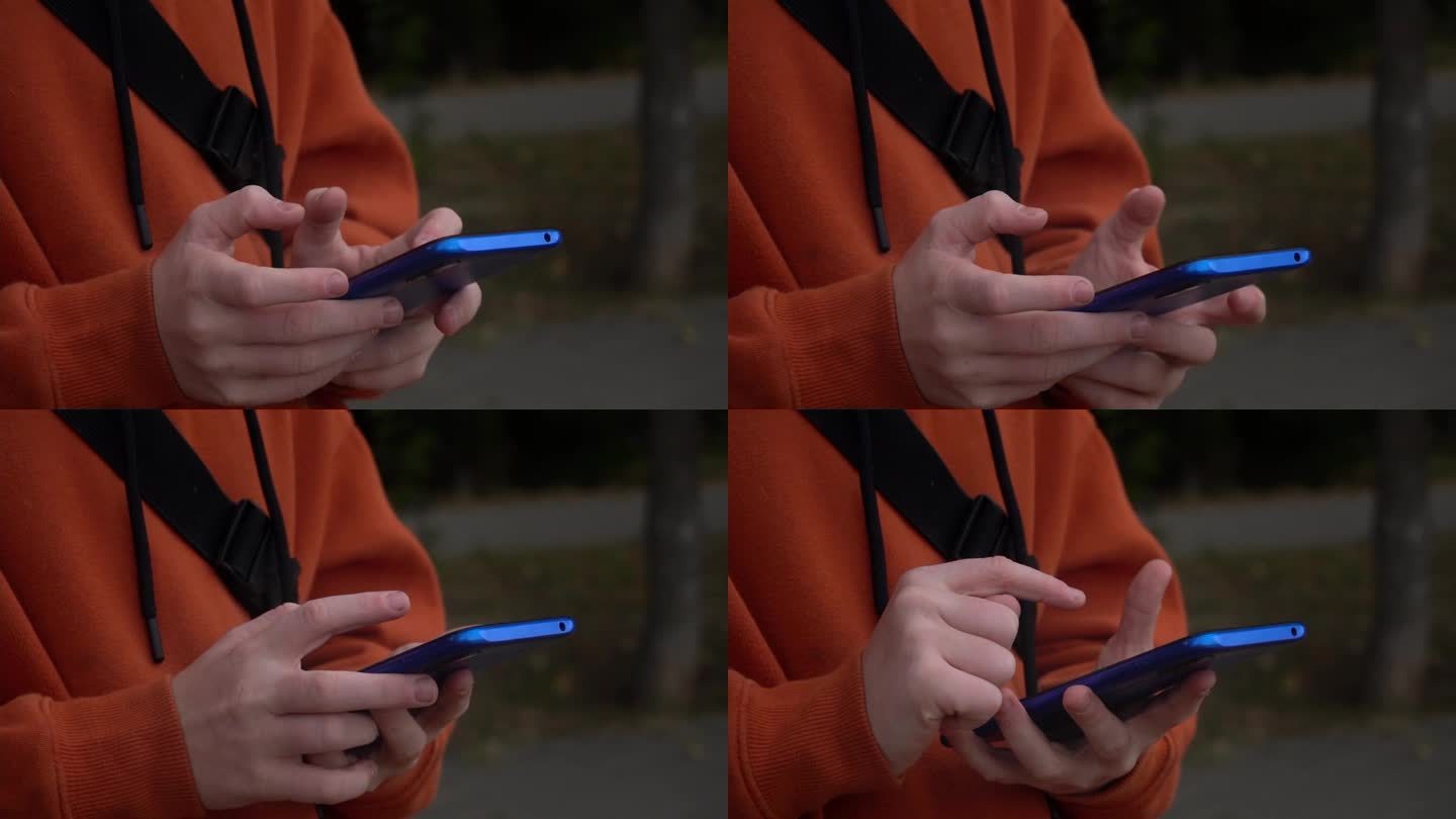 街头少年手中的蓝色智能手机特写。