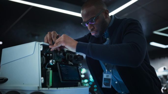 一位非洲工程师在开发遥控送货机器人时使用螺丝刀的特写。拥有现代化设备的高科技研究实验室的黑人专家