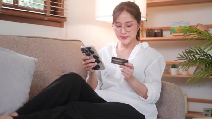 年轻的亚洲女性用手机在网上购物