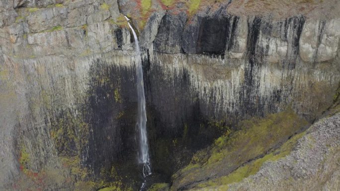 空中倒转拍摄白天冰岛火山景观中的瀑布