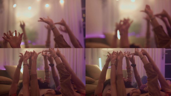 近距离的亚洲朋友的手躺在地板上一起做星形的手在夜间聚会。