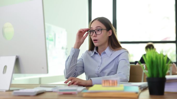 商务女实习生坐在办公室的电脑前，对应付的账单或错误印象深刻