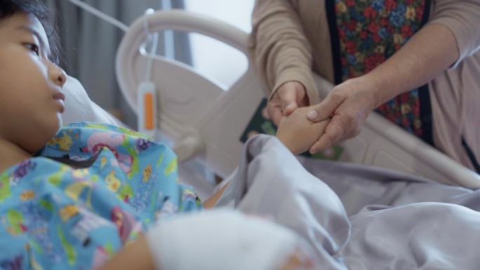 患流感的男孩躺在医院的病床上，他的手连接着输注生理盐水的软管。