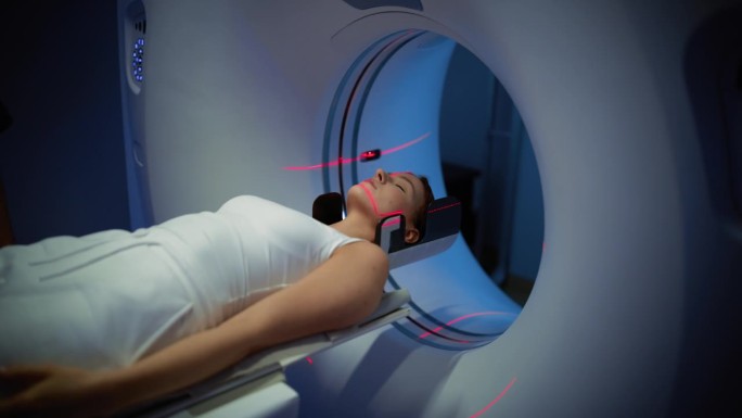 一位躺在CT或MRI扫描上的女性病人的特写肖像，当机器用红色激光扫描她的身体和大脑时，床在机器内移动