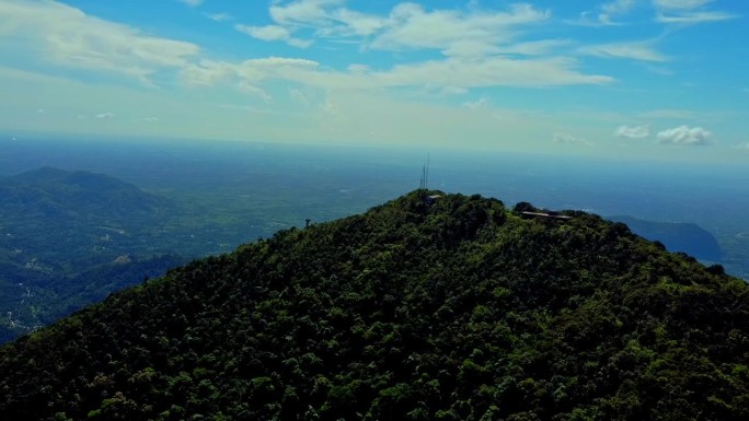 泰国一个森林覆盖的高山高峰的高角度照片。有一个传送电话信号的塔