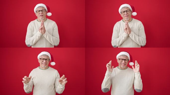 一个白发苍苍的中年男子戴着圣诞帽，在孤立的红色背景上祈求好运