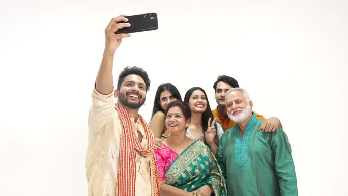 印度幸福的一家人站在一起用手机自拍。