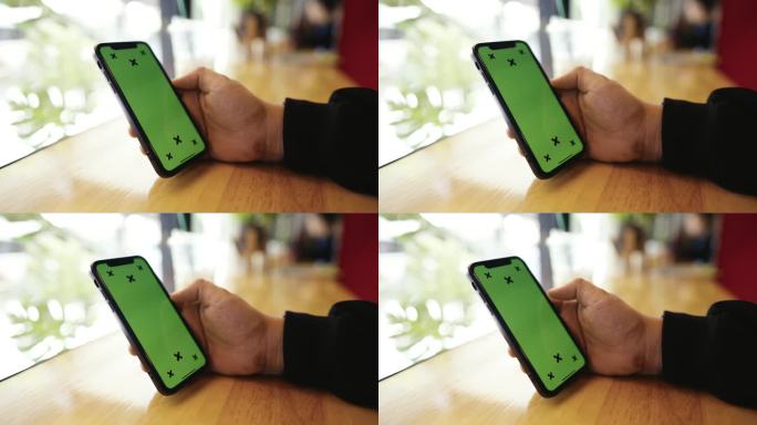 男子在咖啡馆使用绿屏手机