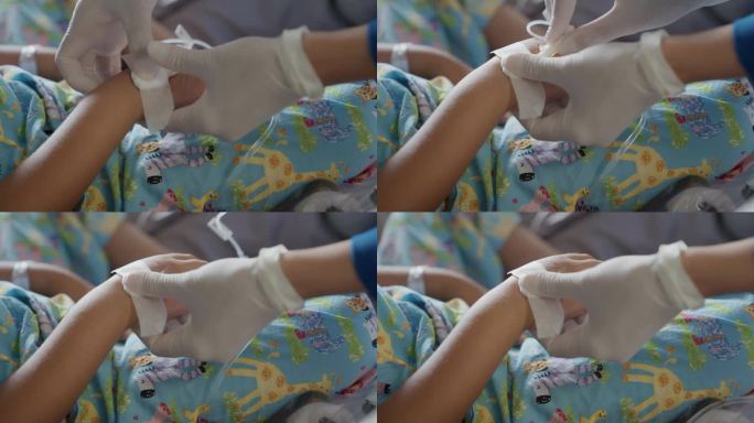 友善的护士在病房里照顾孩子们裹着布的手。
