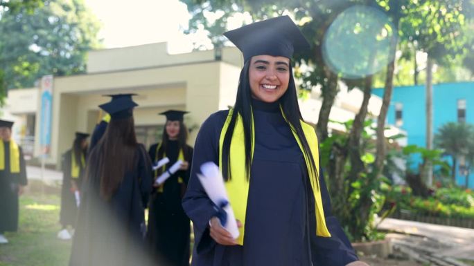 一个快乐的拉丁美洲女毕业生的视频肖像，拿着她的文凭，看着镜头微笑