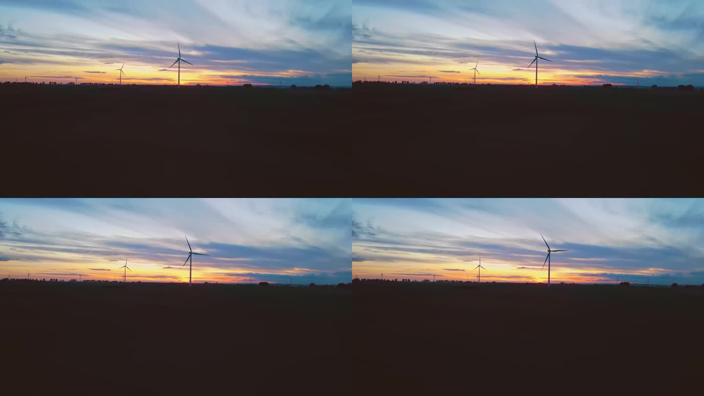 大型风力涡轮机与叶片在野外鸟瞰风车剪影在惊人的多云多彩的日落