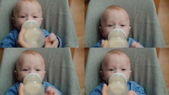 慈爱的妈妈在家里用奶瓶给她的小男孩喂奶，画婴儿宝宝吃、喝奶粉。