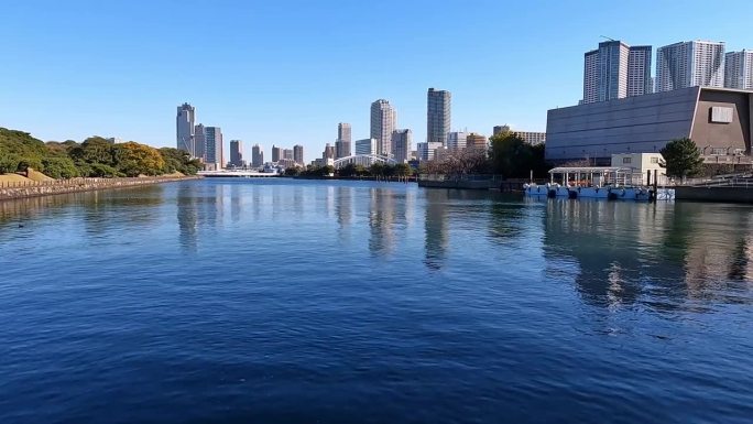 东京竹叶滩平静的蓝色海水。高耸的摩天大楼，现代化的水景。日本