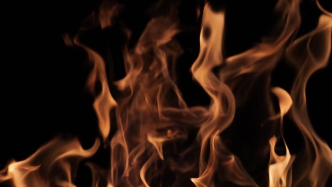 黑色背景上的火焰和火花。一个大篝火。火灾和危险。壁炉里燃烧的木头。浪漫的火。晚上生火。