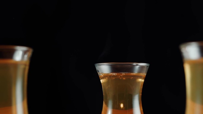 黑底阿穆杜玻璃杯里的红茶。现煮柑橘茶道工艺，健康早晨，排毒饮品。
