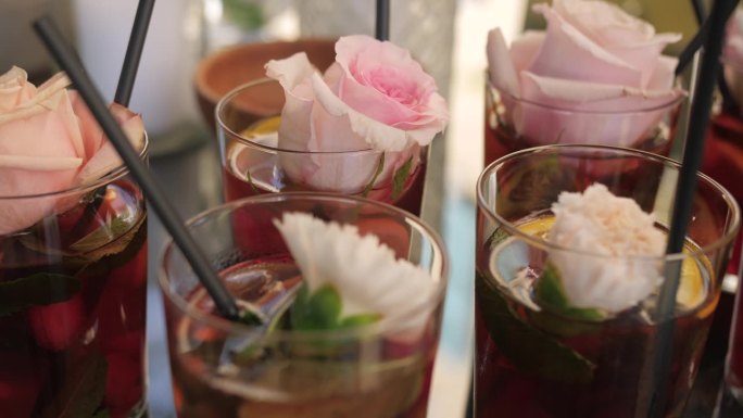 鸡尾酒与玫瑰装饰的玻璃，在聚会上花式饮料的特写镜头