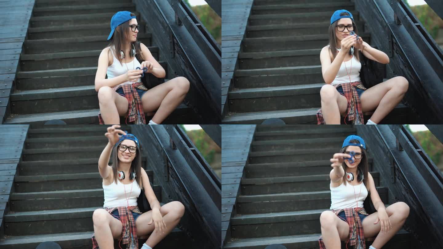 年轻女子坐在户外台阶上玩指尖陀螺