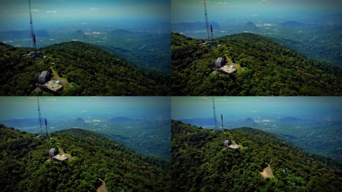 泰国一个森林覆盖的高山高峰的高角度照片。有一个传送电话信号的塔