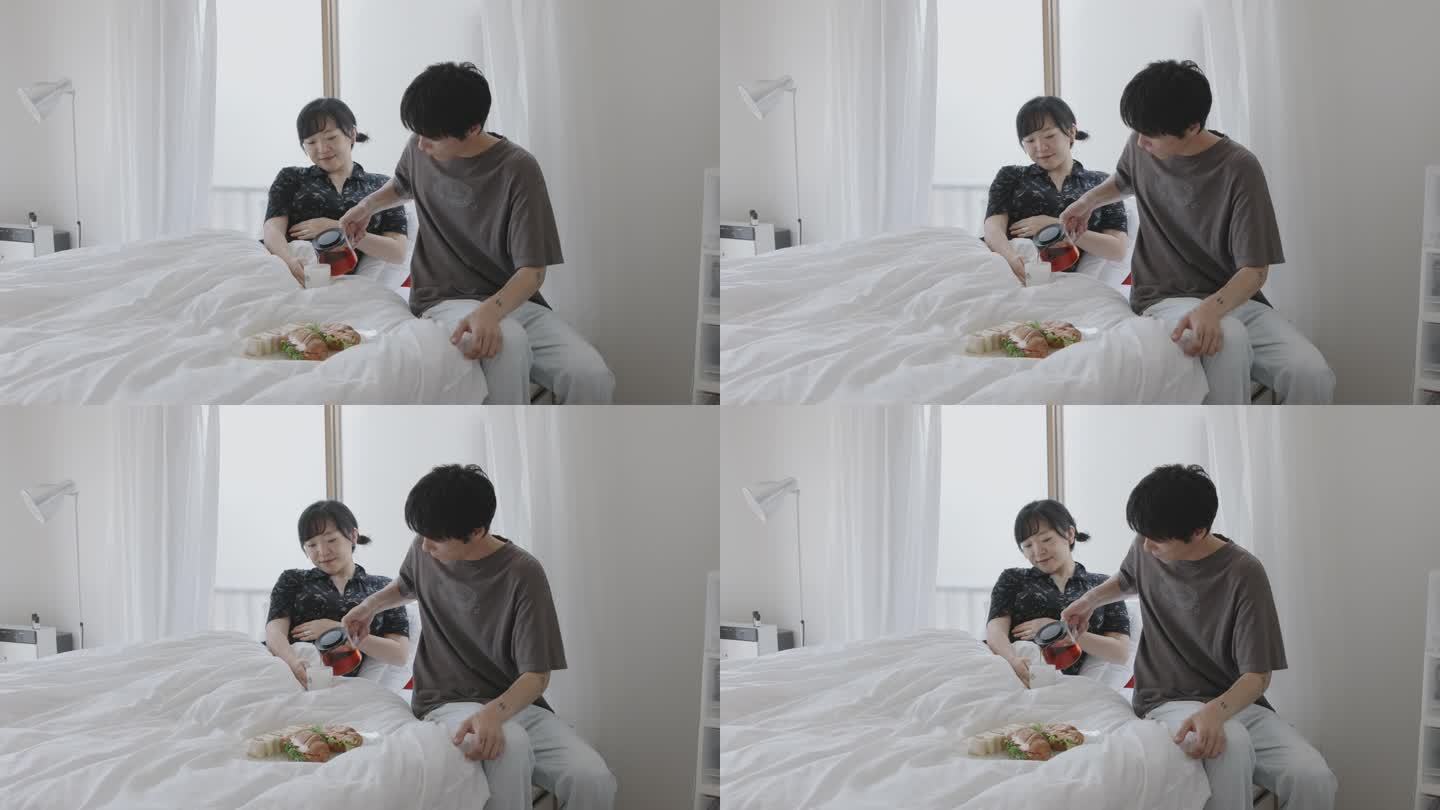 年轻的日本夫妇在床上吃早餐