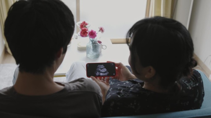 一对年轻夫妇在看他们的婴儿超声录像