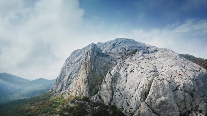 山宽坡陡，全景。一只鸟飞过，低低的云。无人机航拍。