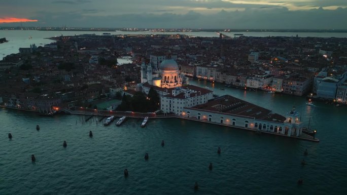 鸟瞰图实时拍摄的圣玛丽亚德拉致敬大教堂俯视图，飞得更高，看到黄昏时分威尼斯大运河上拥挤的交通