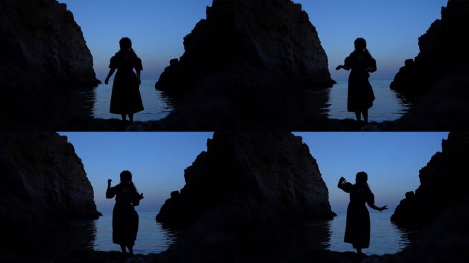 年轻女孩在海边蓝调时刻跳舞剪影