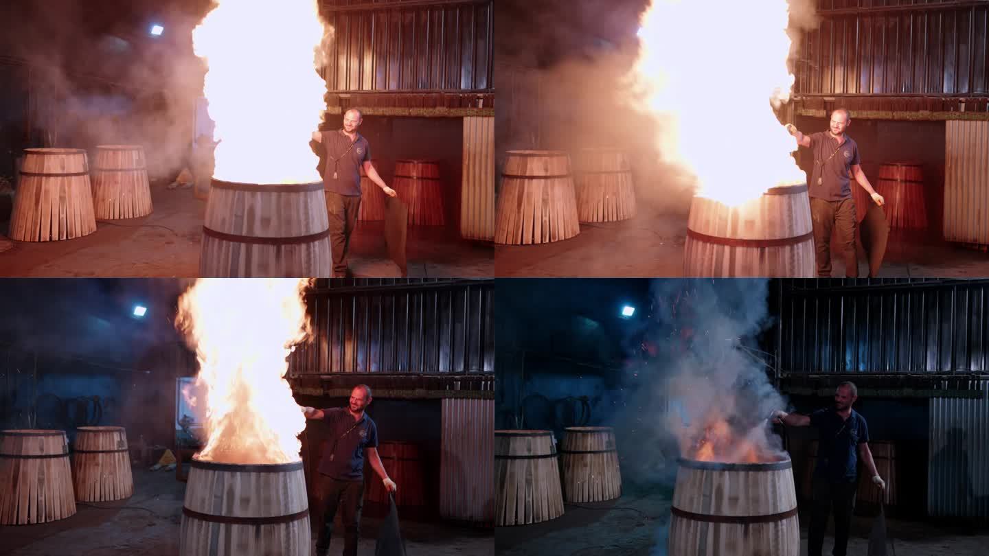 视频4k Prores HQ。赫雷斯的一名工人正在用火烤桶的内部，并用水将桶烧制。赫雷斯制造的酒桶有