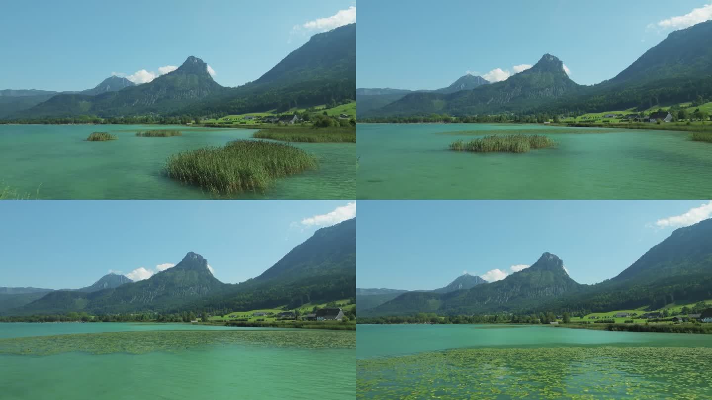低空无人机之旅揭开了奥地利的辉煌:沃尔夫冈湖的原始水域，由雄伟的布莱克旺山构成。空中的美丽。领袖有创