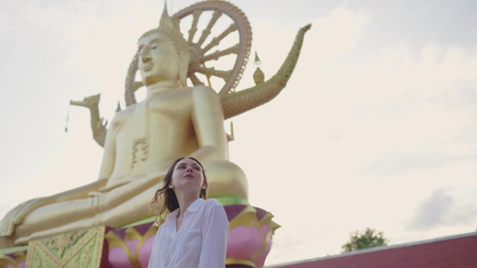 快乐的女人在苏梅岛的大佛寺里探索