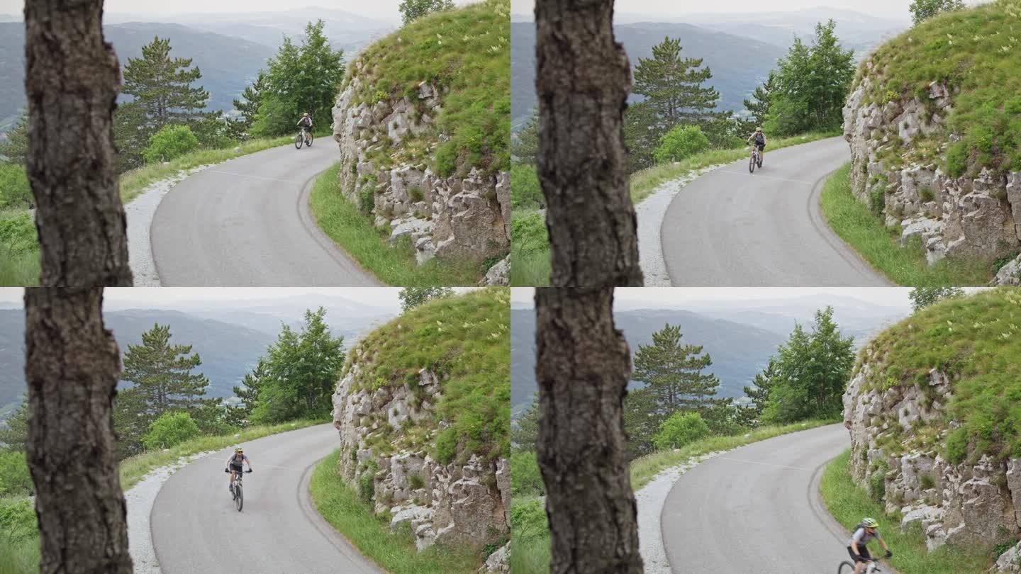 一个骑山地自行车的男人沿着一条漂亮的山路骑着