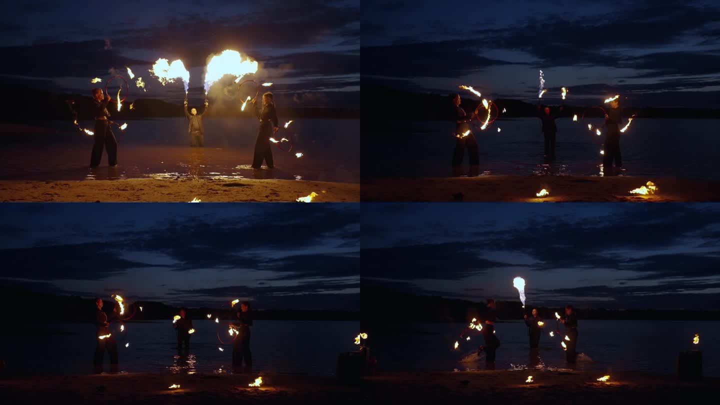 夜河岸边神秘的火焰表演，人们在黑暗中旋转燃烧的火炬