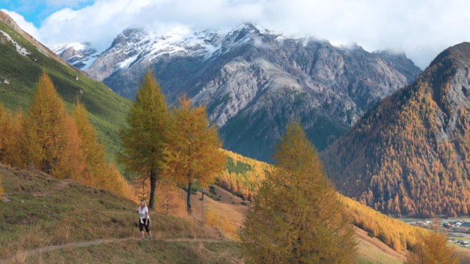 成熟的女性徒步旅行者探索高山山坡，秋天