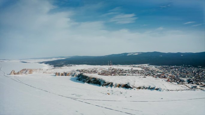 奥尔洪，库日尔，贝加尔湖。无人机拍摄的全岛全景图。白雪覆盖的沙漠。冬村的背景在山上。无人机航拍