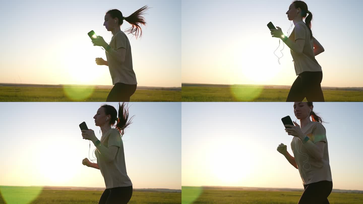 年轻的健身运动女子在日落时分在路上跑步。年轻女子夏天在公园里跑步，戴着耳机听音乐。健康生活方式的概念