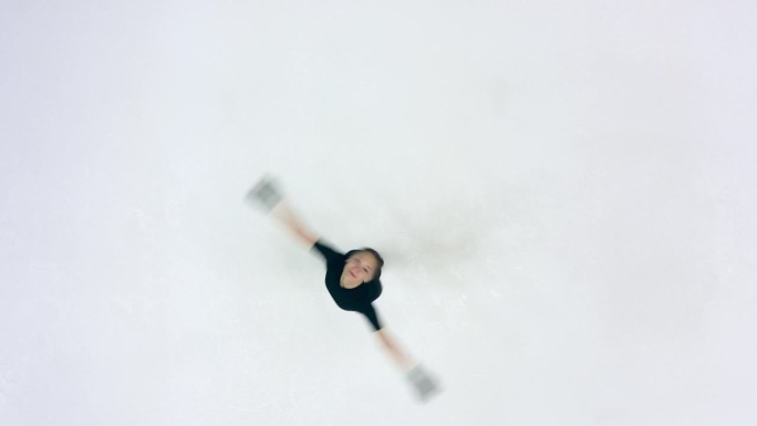 一位女运动员在溜冰场上旋转的俯视图