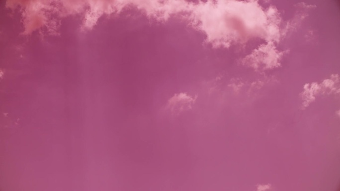 令人惊叹的彩色粉红色的云。延时粉红色调的天空背景。戏剧性的洋红色天空与蓬松的云轮廓。粉色、紫色。的梦