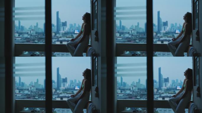 女人坐在阳台上，可以看到大城市和放松