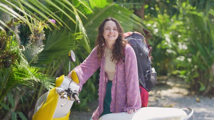 骑摩托车在热带地区旅行的女背包客