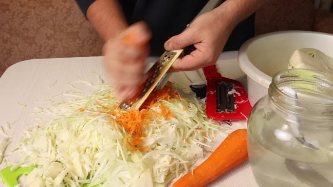 一个男人在家煮酸菜。磨胡萝卜。总体规划。