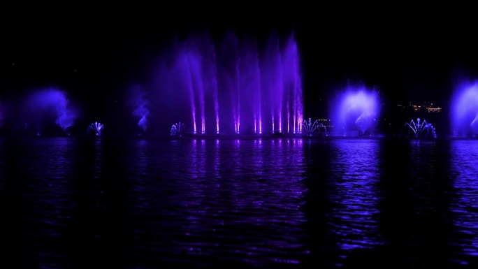 一个美丽的歌唱喷泉，在一个小湖上有五颜六色的水流。