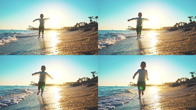 后视图男婴赤脚走在海边的水波与泡沫留下脚印在沙滩上。暑假户外自然风光旅游。孩子们在夕阳下散步。