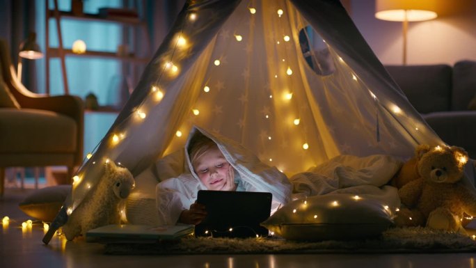 孩子，晚上和快乐的平板电脑在帐篷里上网，游戏或流媒体在卧室里笑。人，小女孩和观看互联网，网页或应用程