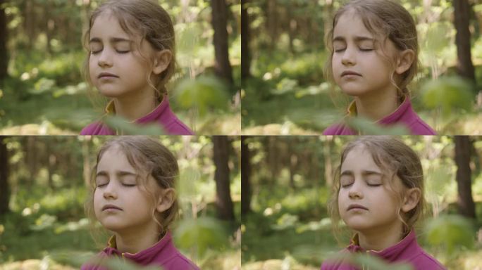 小女孩在森林里呼吸新鲜空气，深呼吸，减压。梦幻宁静轻松微笑的童女呼吸着大自然的新鲜空气，宁静的白种人