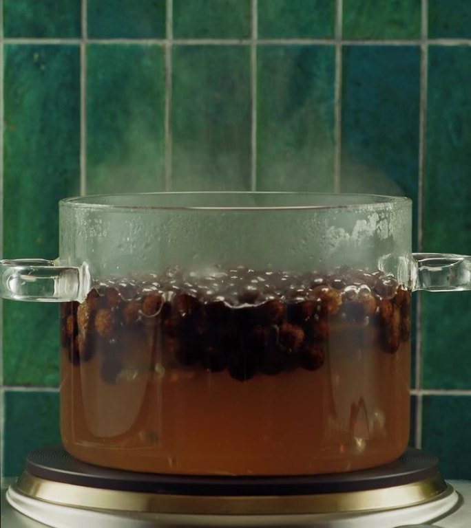 将红糖口味的木薯珍珠放入玻璃锅中煮，制作珍珠奶茶