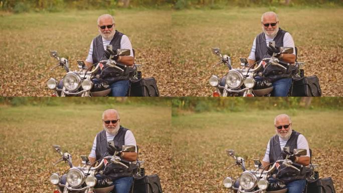 高级男性白人骑摩托车的人像坐在摩托车上，用耳机通过视频通话打电话