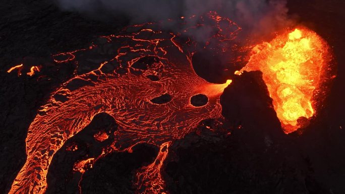 火山喷发，炽热的熔岩从地面喷出，无人机飞过活跃的火山口