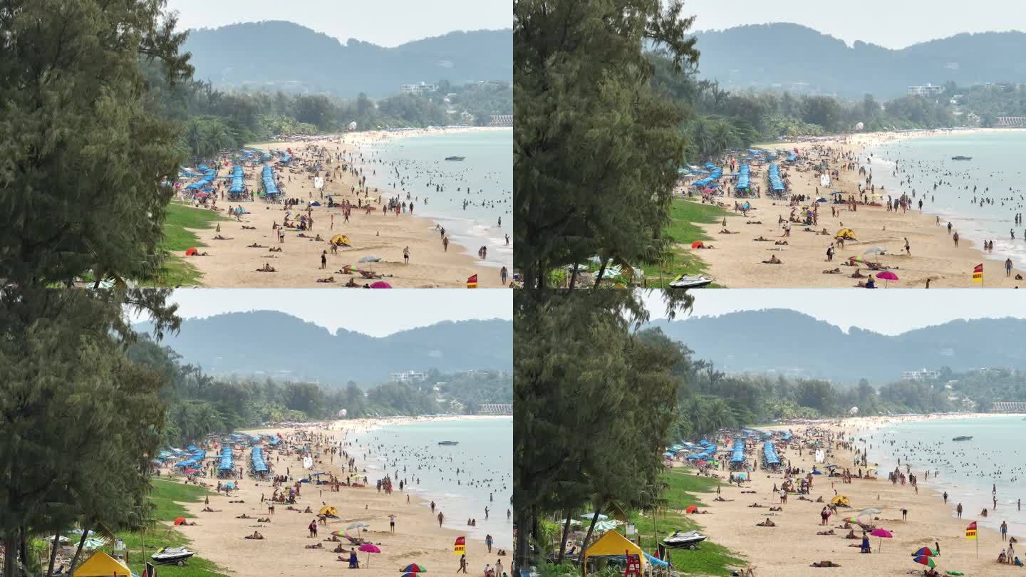 阳光明媚的一天飞越普吉岛著名的旅游拥挤的海滩航拍全景4k泰国