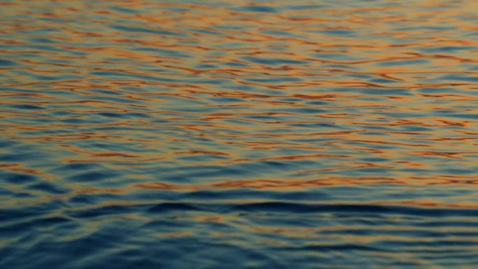 阳光在水面的涟漪中闪烁。美丽的傍晚自然大海背景。缓慢的运动。
