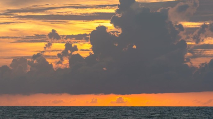 特写的太阳，唤起时间的日落在海上的背景和云。